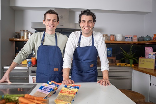 Kev en Dave van Butternut Box met een blauw schort voor in de keuken